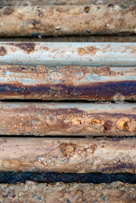 Скачать Подробный макросъемочный снимок ржавых металлических труб, на котором видны слои коррозии, следы окисления и промышленный распад с течением времени. фотосток Ozero