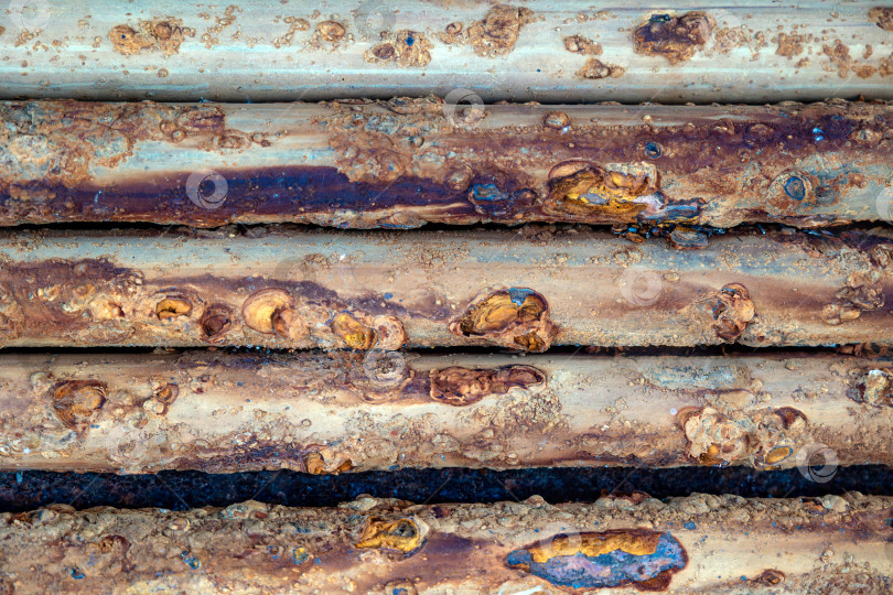 Скачать Подробный макросъемочный снимок ржавых металлических труб, на котором видны слои коррозии, следы окисления и промышленный распад с течением времени. фотосток Ozero