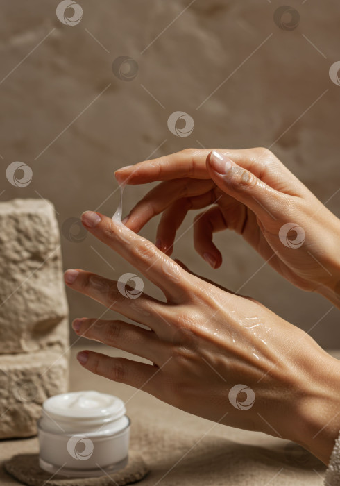 Скачать Женщина, наносящая на руки сыворотку для лица или крем - макет средства по уходу за кожей для рекламы косметических средств. фотосток Ozero