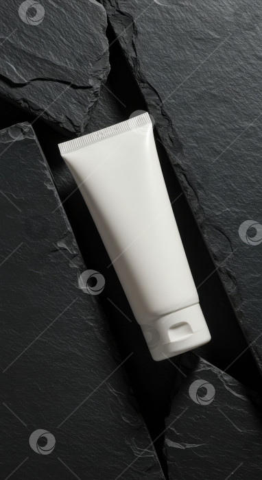 Скачать Чистый белый тюбик косметики на фоне натурального темного сланца. Макет средства по уходу за кожей для красоты, здоровья и личной гигиены. фотосток Ozero