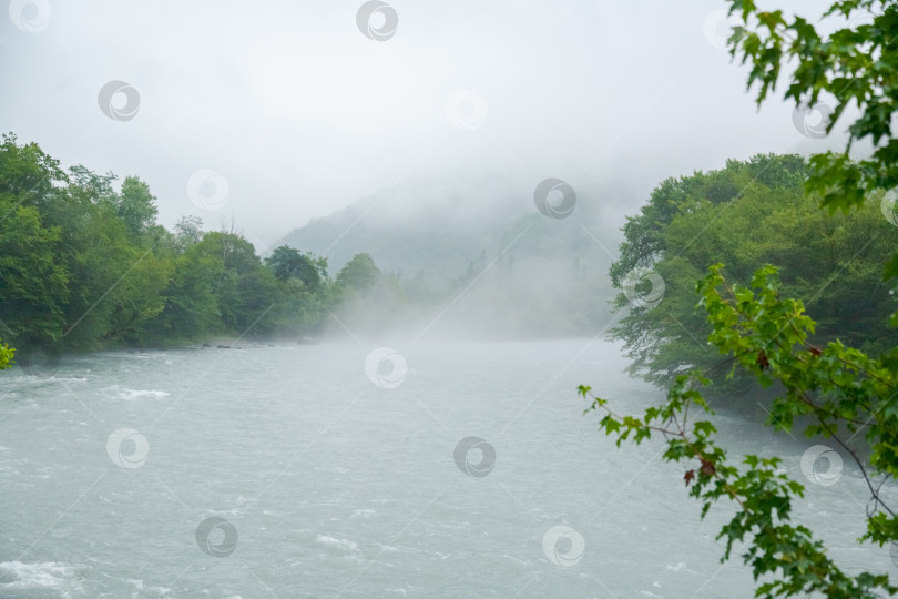 Скачать Река течет вместе с дождем и туманом фотосток Ozero