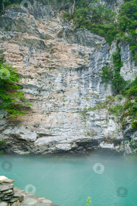 Скачать Большая каменная стена, по которой стекает небольшой ручеек воды фотосток Ozero