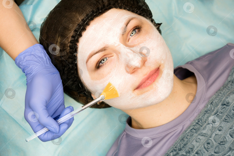 Скачать Женщина получает маску для лица от косметолога фотосток Ozero
