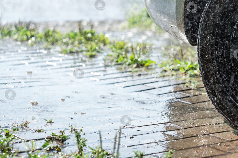 Скачать Сильный летний дождь льет на булыжную мостовую автостоянки фотосток Ozero