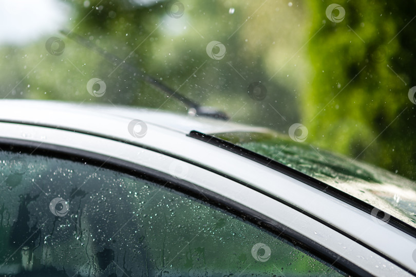 Скачать Сильный летний дождь барабанит по крыше автомобиля фотосток Ozero