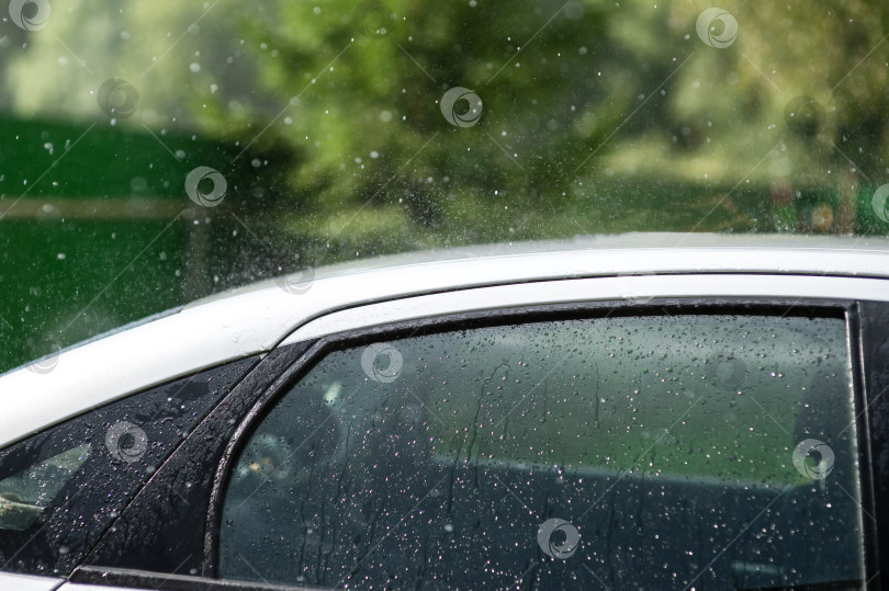 Скачать Сильный летний дождь барабанит по крыше автомобиля фотосток Ozero