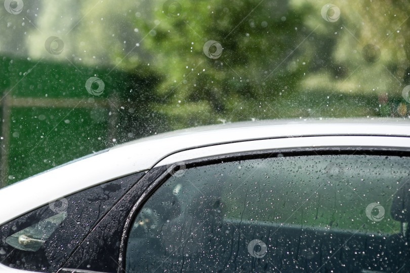 Скачать Сильный летний дождь барабанит по крыше автомобиля фотосток Ozero