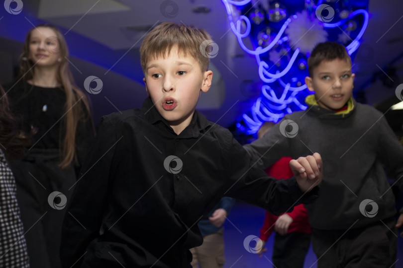 Скачать Счастливые дети танцуют на праздничной вечеринке в клубе, празднуя свой день рождения. фотосток Ozero