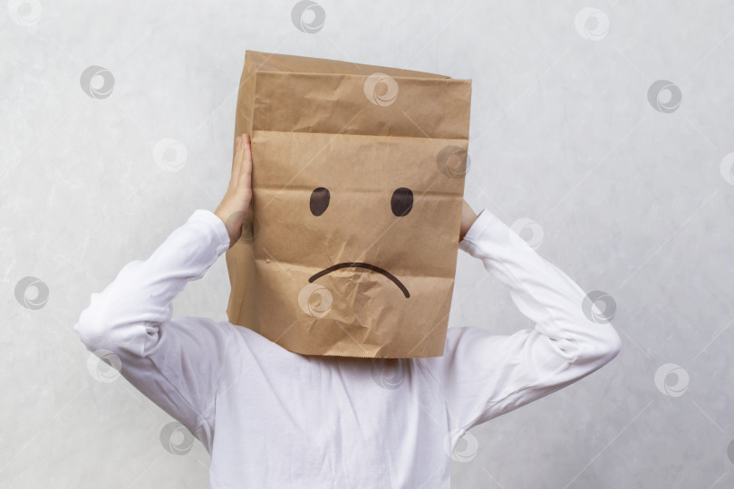 Скачать Ребенок с картонной коробкой на голове, грустный смайлик фотосток Ozero