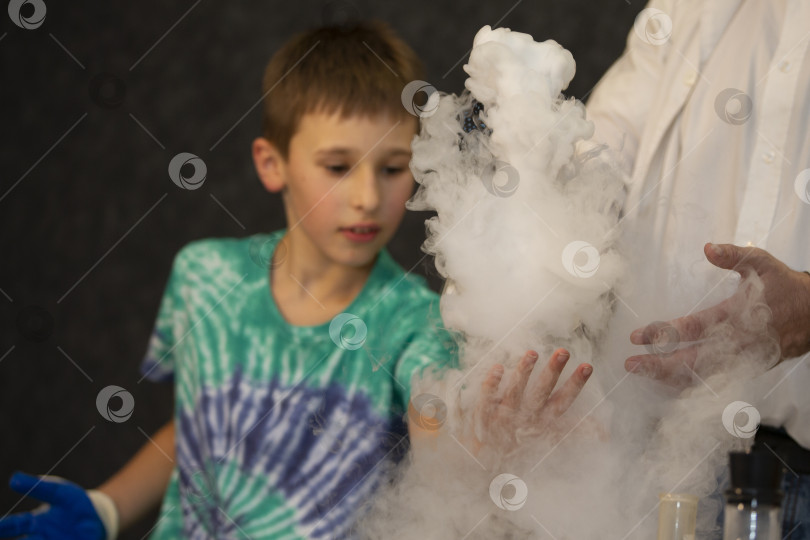 Скачать Мальчик проводит научный химический эксперимент с жидким азотом. фотосток Ozero