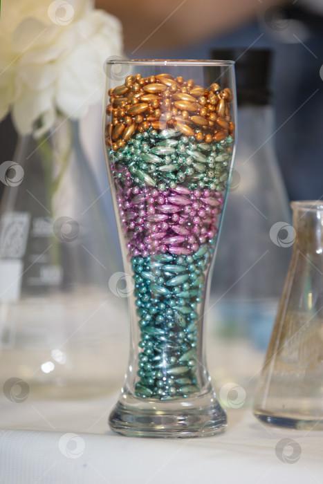 Скачать Разноцветные шарики для лабораторных экспериментов в стеклянном стакане. фотосток Ozero