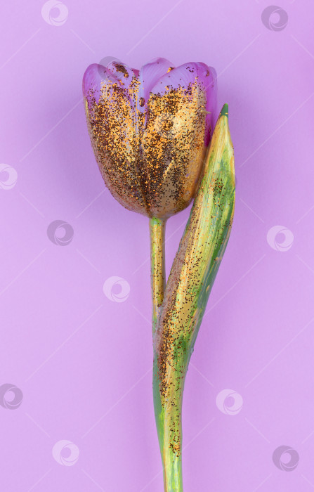 Скачать Красивый цветок, покрытый золотой краской, на розовом фоне. Выделен золотой тюльпан. фотосток Ozero