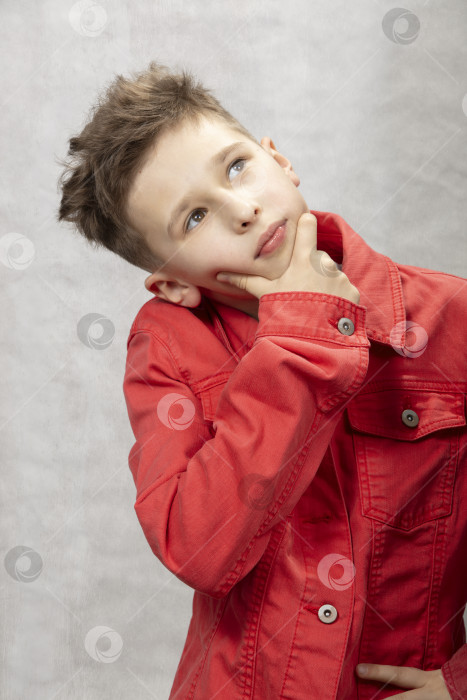 Скачать Задумчивый маленький ребенок в джинсовой куртке на белом фоне. фотосток Ozero