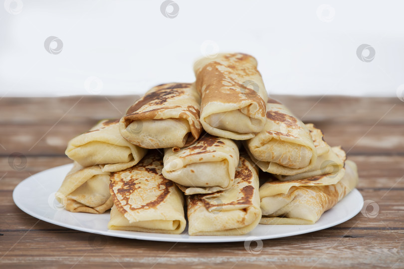 Скачать Блинчики, свернутые трубочкой, выложите на блюдо. Блинчики с начинкой на масленицу. фотосток Ozero