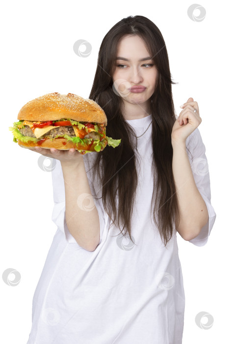 Скачать На заднем плане женщина держит большой бутерброд с гамбургером барбекю. Концепция фаст-фуда. У девушки огромный гамбургер. фотосток Ozero