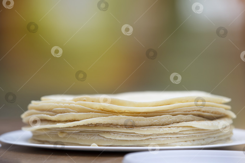 Скачать Тонкие блинчики укладывают стопкой на тарелку. фотосток Ozero