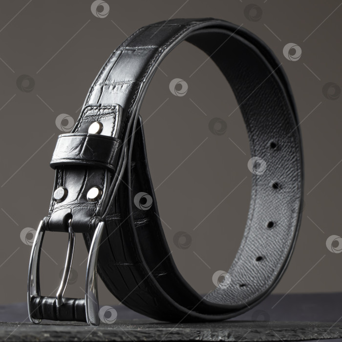Скачать Черный кожаный ремень на темном фоне. Мужской ремень. фотосток Ozero