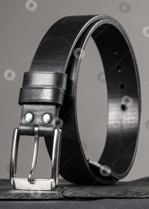 Скачать Кожаный ремень, скрученный в круг на сером фоне. фотосток Ozero