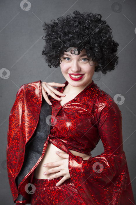 Скачать Возбужденная женщина в африканском парике на сером фоне. Девушка с дискотеки. фотосток Ozero