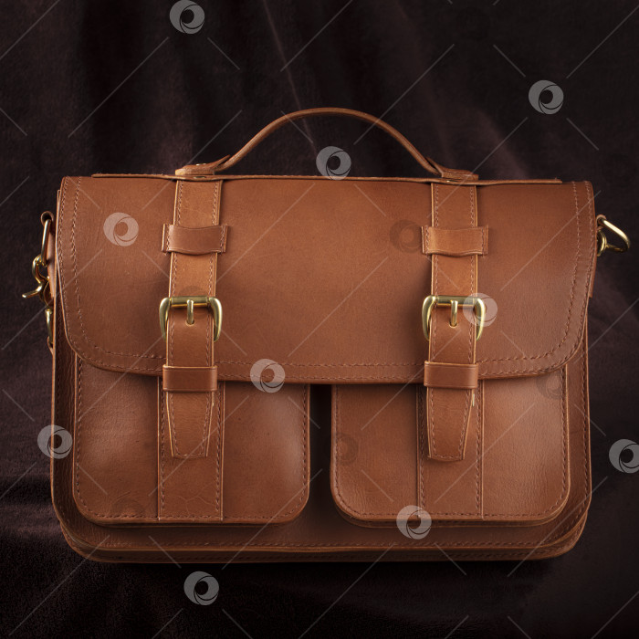 Скачать Коричневая кожаная сумка-портфель на темном фоне. фотосток Ozero