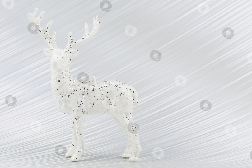 Скачать На серебряном фоне - белый рождественский олень. фотосток Ozero