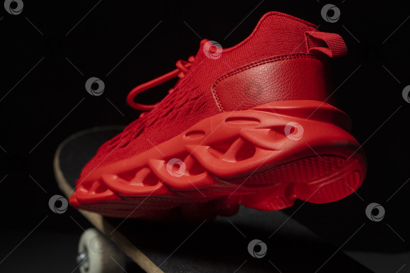 Скачать Красная тканевая кроссовка на скейтборде крупным планом. фотосток Ozero