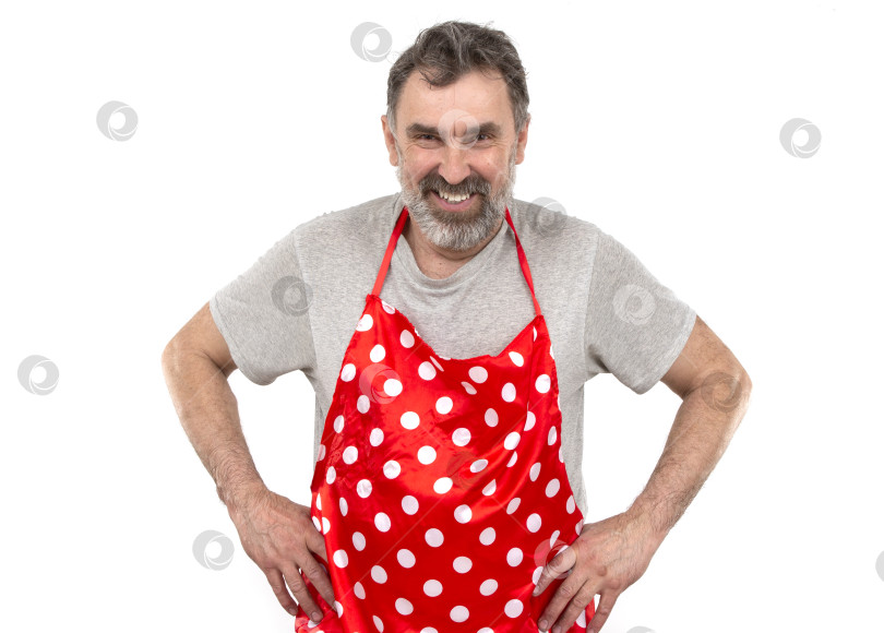 Скачать Пожилой бородатый мужчина в красном кулинарном фартуке в горошек на белом фоне. фотосток Ozero