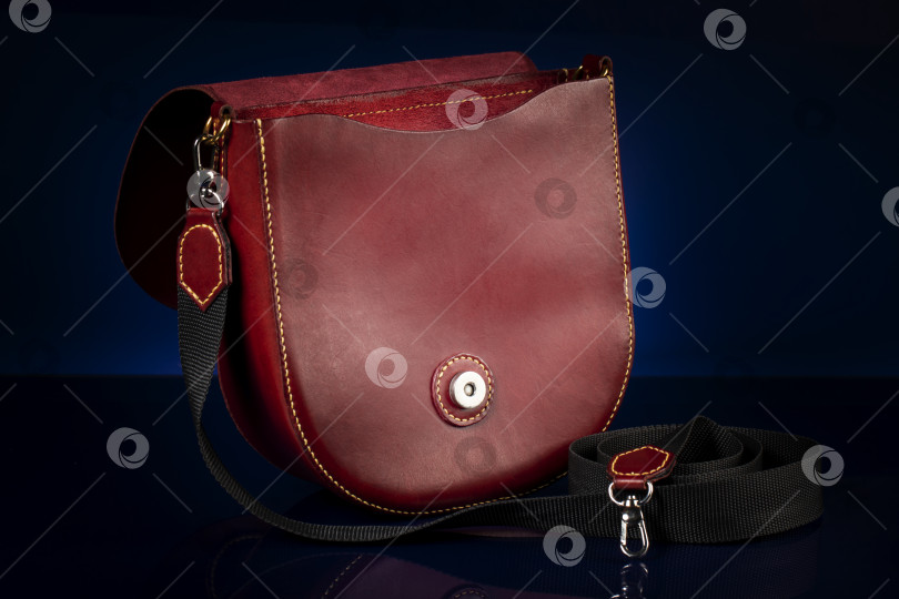 Скачать Кожаная красная сумка на темном фоне. фотосток Ozero