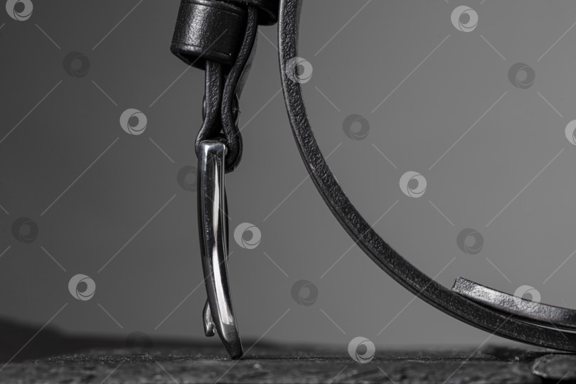 Скачать Часть мужского кожаного ремня на сером фоне. фотосток Ozero