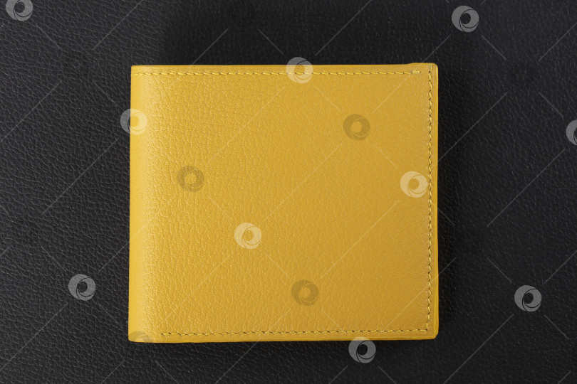 Скачать Изделия из кожи. Бумажник-визитница из желтой кожи на черном фоне. фотосток Ozero