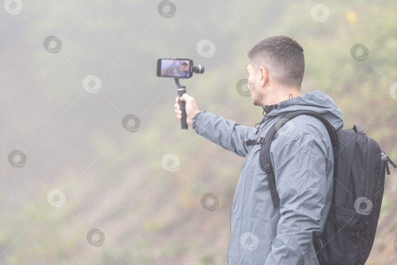 Скачать Мужчина записывает видео для блога в туманный день фотосток Ozero