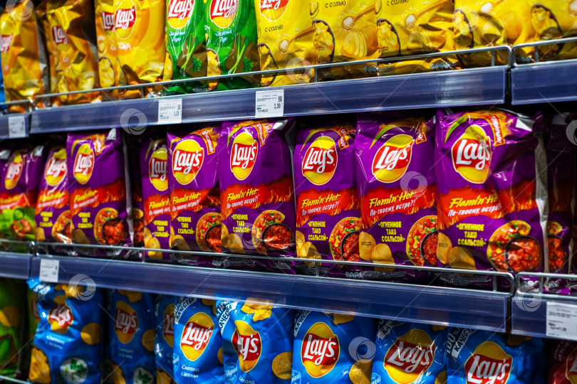 Скачать Беларусь, Минск - 23.05.2025: Пакеты с чипсами Lays аккуратно расставлены на полках в магазине фотосток Ozero