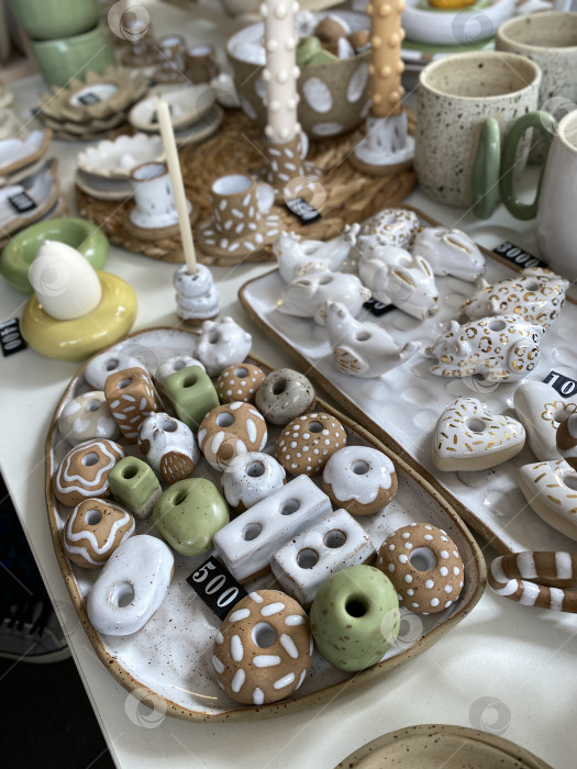 Скачать На столешнице представлена разнообразная керамическая посуда с уникальным дизайном в форме пончиков фотосток Ozero