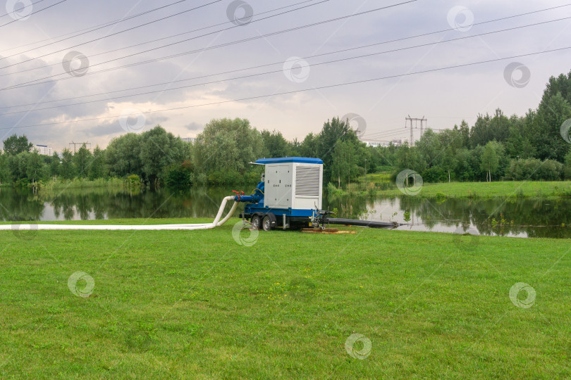 Скачать насос откачивает воду из парка, затопленного во время дождей фотосток Ozero