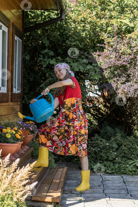 Скачать Портрет девочки-подростка с лейкой в руках и в желтых резиновых сапогах фотосток Ozero
