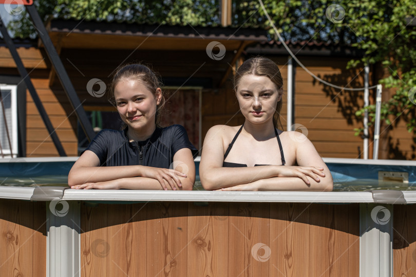 Скачать Две сестры-подростка плавают в бассейне фотосток Ozero