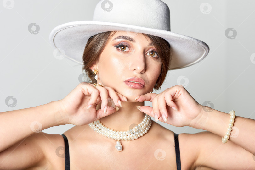 Скачать Женщина в черном платье и белой шляпе в студии фотосток Ozero