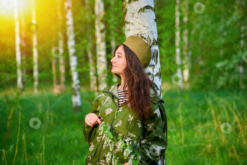 Скачать Женщина в военной форме стоит в лесу фотосток Ozero