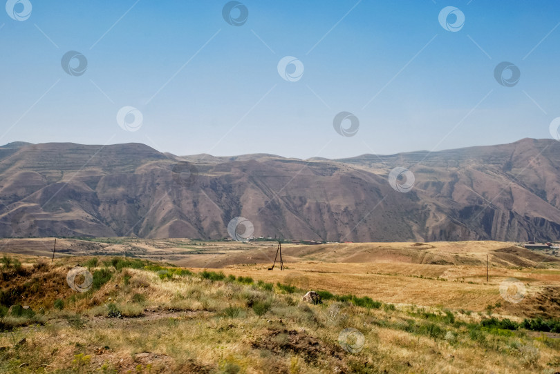 Скачать Панорамный вид на засушливый горный хребет и луга под ясным голубым небом фотосток Ozero