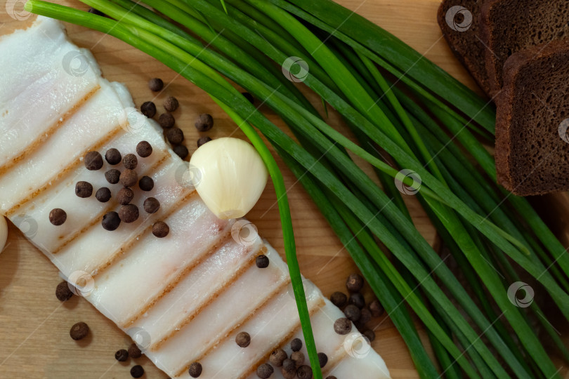 Скачать нарезанный бекон, лук, чеснок, специи и столовые приборы для сервировки стола в деревенском стиле фотосток Ozero