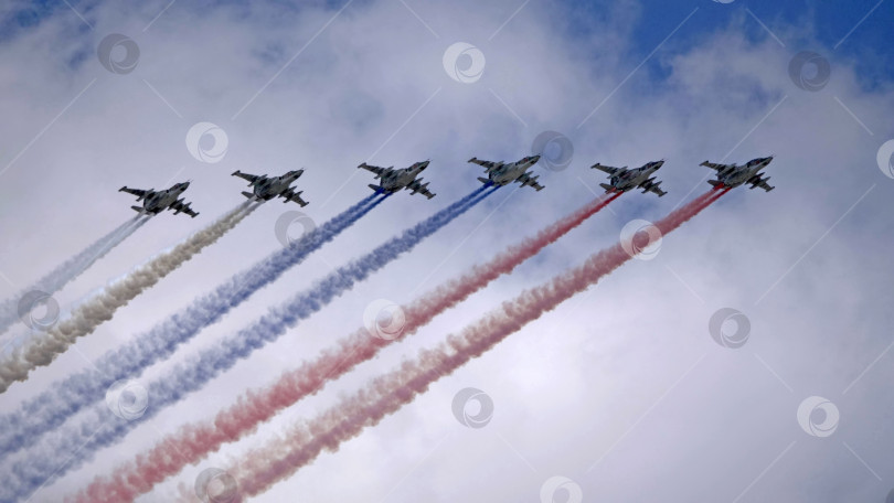 Скачать МОСКВА, РОССИЯ - 7 мая 2021 года: Авиационный парад в Москве. Группа российских истребителей Су-25 с нарисованным российским флагом в небе на параде Победы во Второй мировой войне в Москве, Россия фотосток Ozero