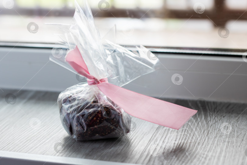 Скачать Аппетитно завернутый кусочек шоколада с розовой ленточкой фотосток Ozero