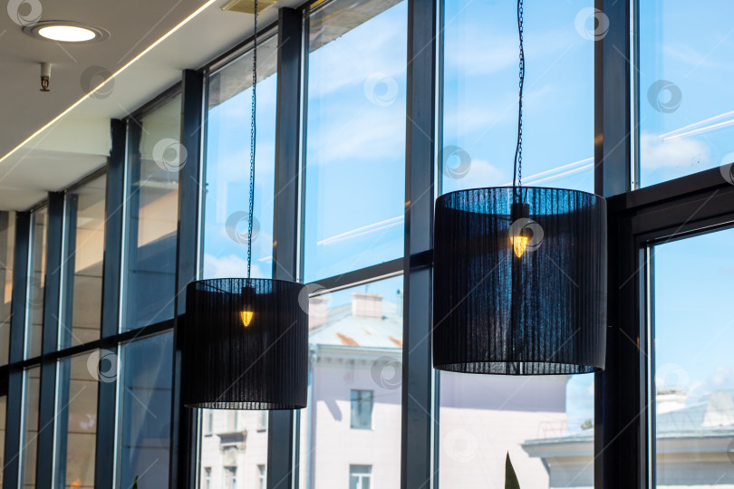 Скачать Здание с множеством окон и черными лампами под потолком фотосток Ozero