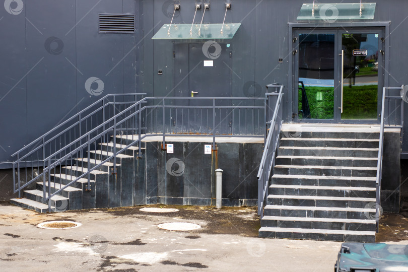 Скачать Ко входу в высокое черное здание ведет лестница фотосток Ozero