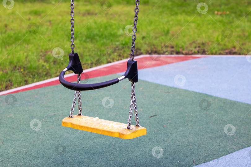 Скачать В парке на прочных цепях подвешены ярко-желтые качели фотосток Ozero