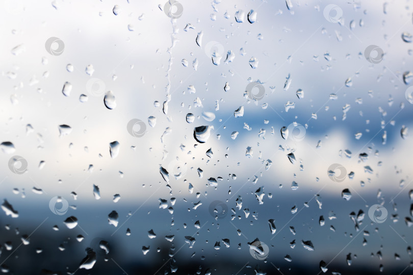 Скачать Капли дождя мягко барабанят по окну, в то время как над головой нависает облачное небо фотосток Ozero