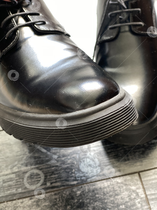 Скачать Строгие туфли из черной кожи на темном деревянном полу демонстрируют безупречную элегантность и стиль фотосток Ozero