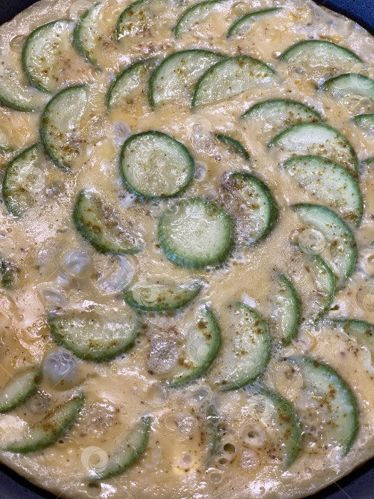 Скачать Приготовление фриттаты с нарезанными цуккини и яичной смесью на сковороде в стиле домашней кухни фотосток Ozero