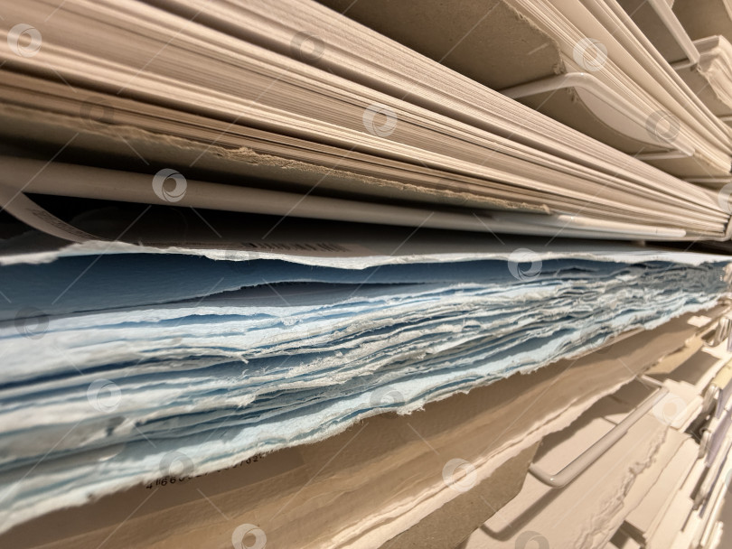 Скачать Стопки различных бумаг, разложенные горизонтально на полках фотосток Ozero