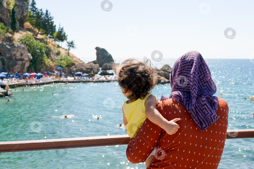 Скачать Женщина с ребенком на руках на пирсе у океана фотосток Ozero